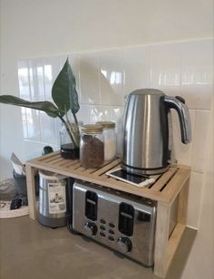 a toaster and coffee maker on a wooden shelf