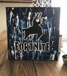 a wooden table topped with a painting of a black and white dog on it's face