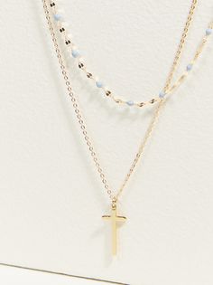 This dainty double chain necklace has the sweetest light blue beads that accent the Cross charm. This cross necklace is a jewelry staple perfect for pairing with any look in your closet for some color and added style. Blue Necklace With Adjustable Chain For Layering, Blue Delicate Chain Necklace, Blue Trendy Jewelry With Delicate Chain, Blue Dainty Chain Necklace With Delicate Chain, Dainty Blue Chain Necklace With Delicate Chain, Blue Dainty Chain Necklace, Dainty Blue Delicate Chain Necklace, Light Blue Multi-strand Jewelry As Gift, Light Blue Multi-strand Jewelry For Gift