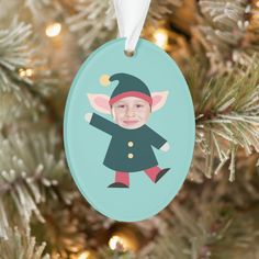 a christmas ornament hanging from a tree with a photo of a baby's face on it