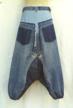 an old pair of jeans hanging on a wall with the bottom section cut out to show it's pockets