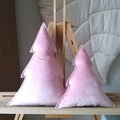 two pink pillows sitting on top of a wooden table