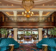 an elegant lobby with blue couches and chandelier