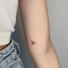 a small bee tattoo on the left inner arm and lower arm is shown in black ink