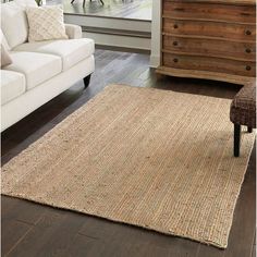 a living room scene with focus on the area rugs and the furniture in the background