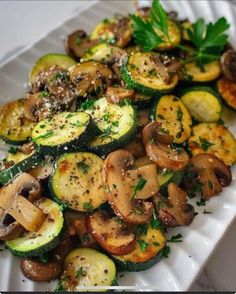 zucchini and mushrooms on a white plate with parsley sprinkled on top