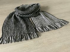 a black and white scarf laying on top of a wooden floor