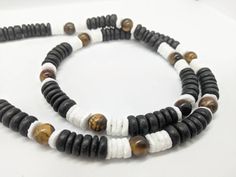 "Men's surf necklace / extra wide 8mm Hawaiian style necklace in your choice color including black coconut, and white Puka shell. CHOOSE from turquoise, brown tiger's eye, tan picture Jasper or teal green as you place the order. Lobster clasp is available by request in order notes. QUALITY: Hand beaded on multi strand coated stainless steel beading wire. Secure screw in clasp or lobster clasp... Your choice! Durable, quality made design. TO SEE MORE MENS CROSS NECKLACE IDEAS click here. https:// Black Natural Stones Jewelry For Beach, Black Spiritual Necklace For Beach, Surf Necklace, Hawaiian Necklace, Puka Shell Necklace, Mens Cross Necklace, Brown Tiger Eye, Surfer Necklace, Necklace Ideas