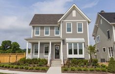 two gray houses with white trim and windows