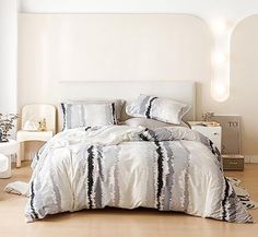 a bed with white and black comforters in a room