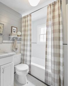 a bathroom with a toilet, sink and shower curtain