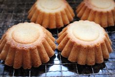 four small cakes sitting on top of a cooling rack