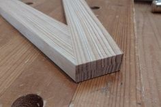 a piece of wood sitting on top of a wooden floor next to a screwdriver