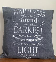 a pillow with the words happiness can be found even in the darkest light on it