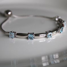 This sterling silver 3 mm Sky Blue Topaz Gemstone Bolo Bracelet is simply elegant. She'll love the versatility this bracelet offers as it pairs amazingly with fine fashion and casual wear. The bracelet is comfortable and easy to adjust to your liking with the pull tie and ball clasp. A thoughtful gift for a March Birthday and a variety of other occasions and events. Explore All Of Our Timeless Jewelry: https://www.etsy.com/shop/JOHNWESHDESIGNS All JohnWeshDesigns jewelry is handcrafted and desig Adjustable Fine Jewelry Bracelets With Stones, Fine Jewelry Bracelets With Stones, Adjustable Sterling Silver Bracelet With Birthstone For Anniversary, Classic Silver Bracelets With Birthstone, Classic Silver Bracelet With Birthstone, Classic Silver Birthstone Bracelets, Elegant Adjustable Sterling Silver Birthstone Bracelet, White Gold Bracelet With Gemstone Accents For Gift, Elegant Aquamarine Silver Bracelets