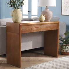 a living room with a couch, table and two vases