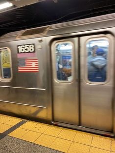 a subway train with its doors open and people standing on the platform next to it