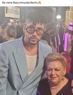 two people standing next to each other in front of a crowd on the red carpet