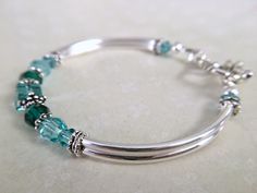 This bracelet has been uniquely created by combining emerald and light turquoise crystals together. Such a pretty combination! Perfect for your upcoming wedding to gift to your bridesmaids, mother of bride/groom, Jr bridesmaids, etc. OR, a great birthday, anniversary or just because gift. Choose from a toggle or lobster claw clasp from the dropdown menu at checkout. ~ 6mm and 4mm emerald and lt turquoise swarovski crystals ~ sterling silver bead caps ~ silver plated curbed tube bead bangles and Adjustable Turquoise Jewelry For May Birthstone, Elegant Turquoise Birthstone Bracelets, Green Bracelet Jewelry For Birthday Gift, Adjustable Turquoise Bracelet With Birthstone, Green Bracelet For Birthday Gift, Adjustable Turquoise Birthstone Jewelry, Dainty May Birthstone Bracelets For Anniversary, Turquoise Birthstone Bracelet, Elegant Personalized Turquoise Jewelry