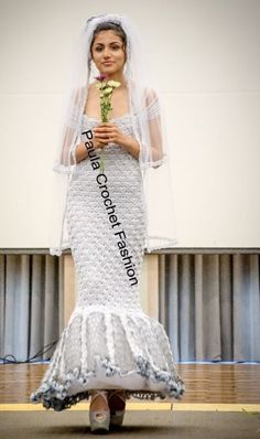 a woman in a wedding dress on a skateboard holding a flower and posing for the camera