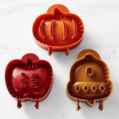 three pumpkin shaped cookie cutters sitting on top of a white counter next to each other