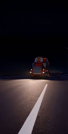 a truck driving down the road at night