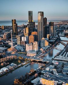 an aerial view of a city with lots of tall buildings in the foreground and a river running through it