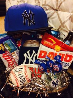 a new york yankees hat, baseball cap, candy and snacks in a gift basket