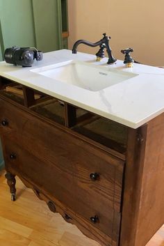 a bathroom sink sitting on top of a wooden cabinet