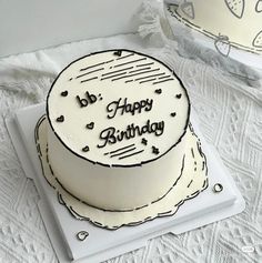 a birthday cake with the words happy birthday on it sitting on a white tablecloth