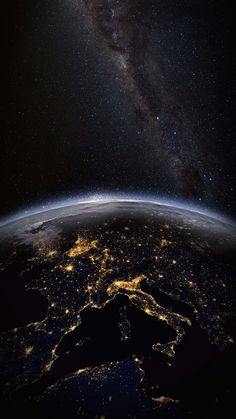 the earth at night from space with stars and milky in the background, as seen from space