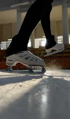 a person riding skis on top of snow covered ground in front of a building