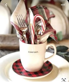 a cup filled with silverware sitting on top of a plate