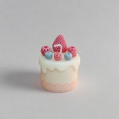 there is a small cake with pink and blue decorations on it's icing