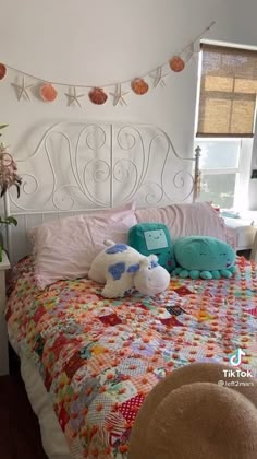 there is a bed that has many pillows on it and some decorations hanging from the headboard