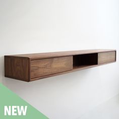 a wooden shelf mounted to the side of a wall next to a green and white background