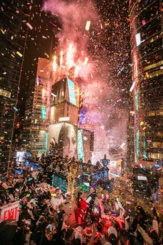 fireworks and confetti are thrown in the air as people walk down a city street