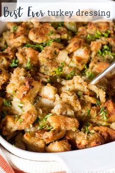 a casserole dish filled with stuffing and garnished with parsley