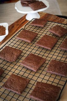 chocolate crackers cooling on a wire rack with bowls of powdered sugar in the background