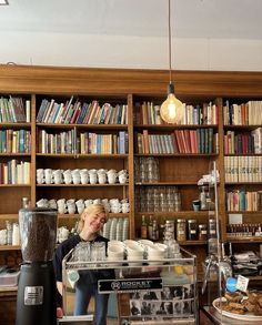 a woman standing in front of a coffee machine