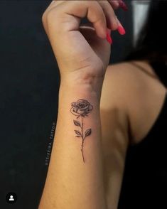 a woman's arm with a rose tattoo on the left side of her wrist