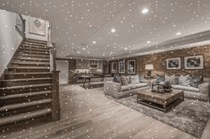 a living room filled with lots of furniture and a staircase leading up to the second floor