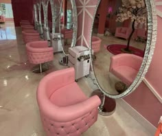 a room with pink chairs and mirrors in it