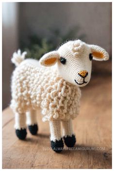 a knitted sheep sitting on top of a wooden table