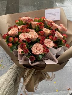 a bouquet of roses wrapped in brown paper