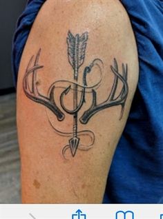 a tattoo on the arm of a man with an arrow and antlers in it