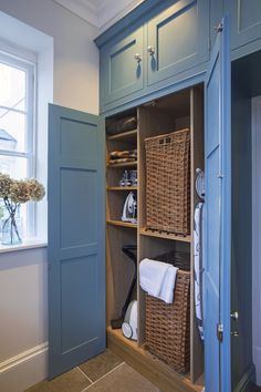 a blue cabinet with baskets and towels in it