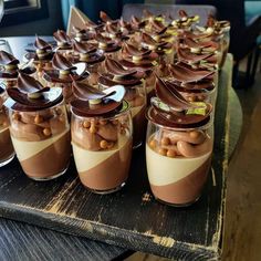 there are many desserts in glass jars on the table