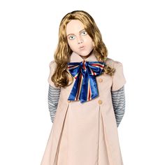 a doll dressed in a pink dress with a blue bow around her neck and long hair