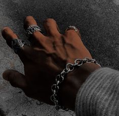 a hand with chains on it holding onto a skateboard